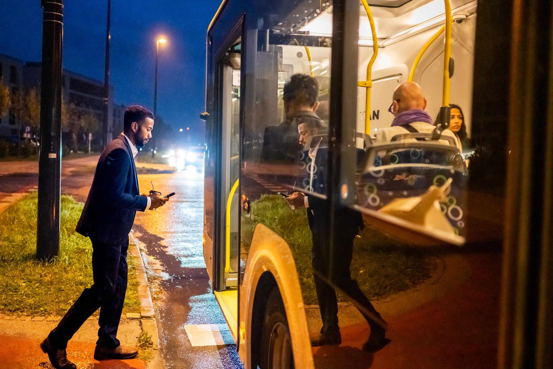 Commuter boarding a city bus in the evening