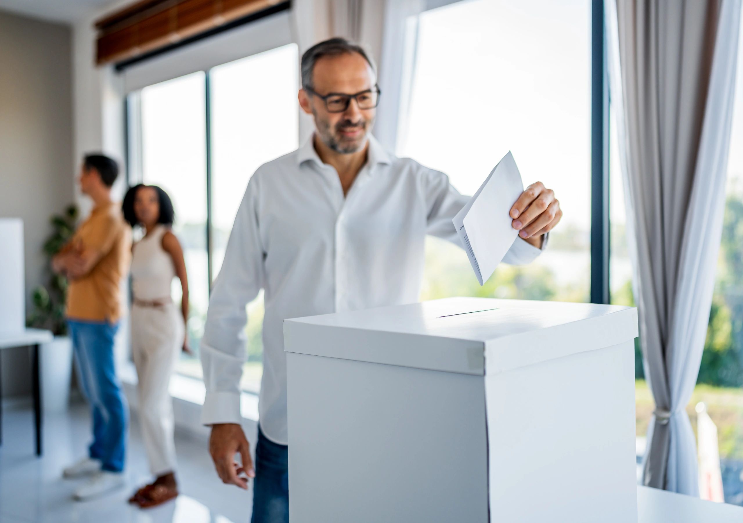 Voters casting ballots into a ballot box